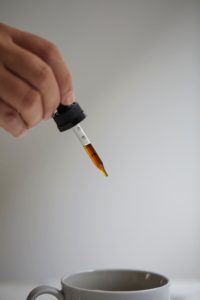 Tanasi CBD tincture over coffee cup