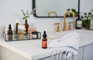 Tanasi CBD tincture on white bathroom countertop