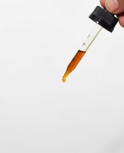 CBD tincture dropper on white background