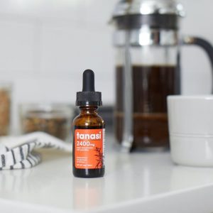 CBD Tincture on white counter with coffee in background