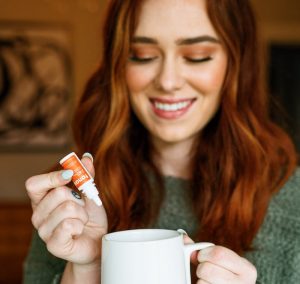 Red haired woman using CBD water soluble
