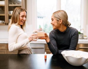 Women using Tanasi CBD water soluble in their drinks with popcorn on counter