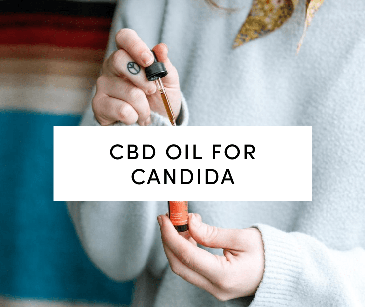 Woman in white sweater holding Tanasi CBD oil tincture