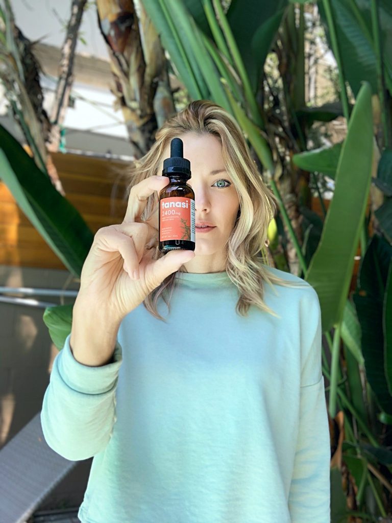 Brittney Bouchard influencer holding up tanasi cbd oil tincture