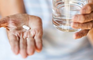 woman taking an ibuprofen pill for pain